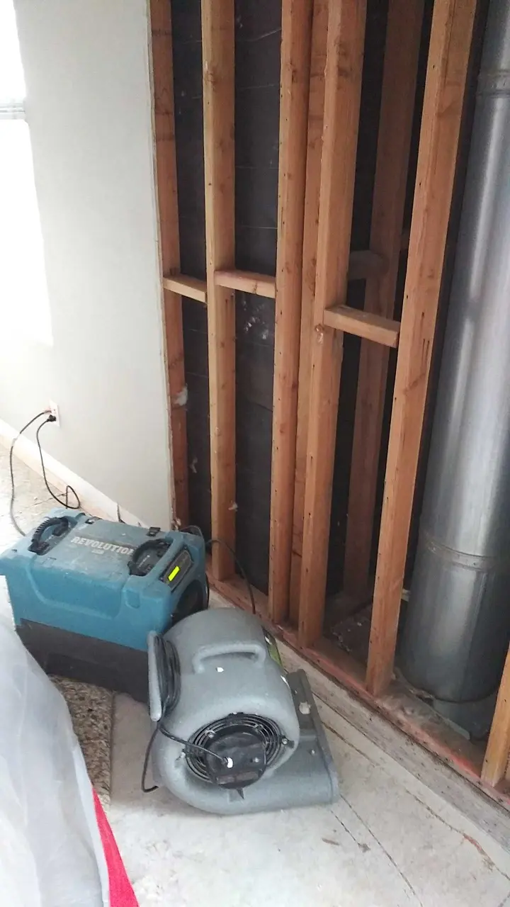 Opened wall cavity and drying equipment during Beaumont water damage mitigation
