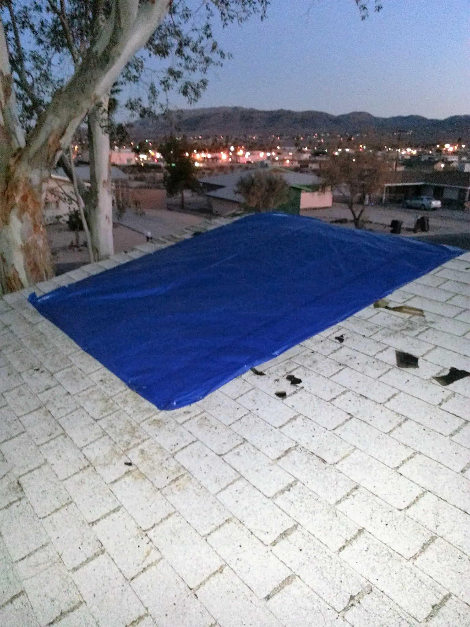 Twentynine Palms garage fire emergency board up and roof tarp project by PL Builders showing blue roof tarp installed after garage fire