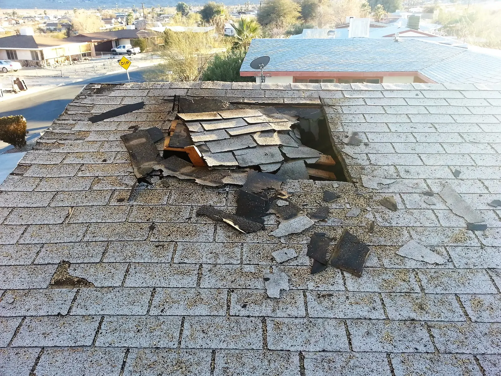 Twentynine Palms garage fire emergency board up and roof tarp project by PL Builders showing roof opening after garage fire before tarp protection