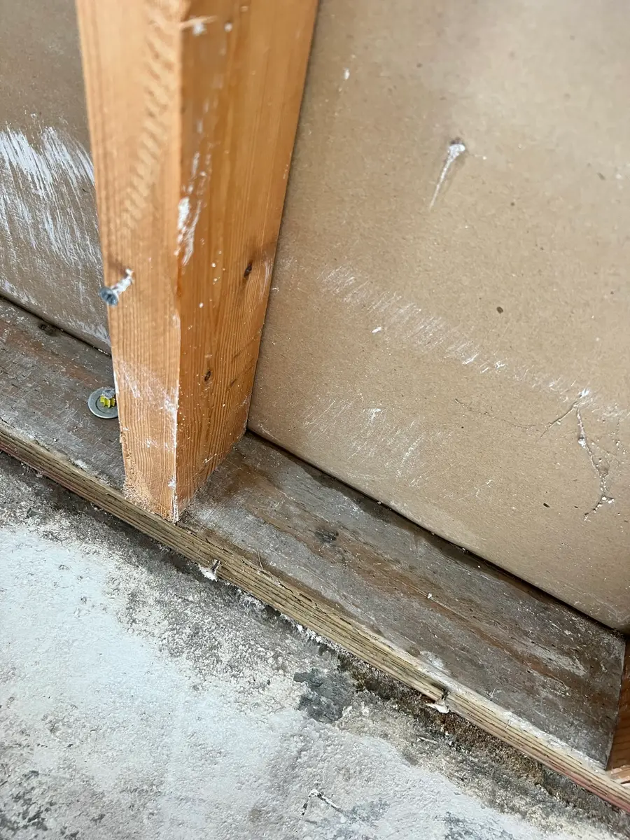 Water-damaged wall base opened near kitchen cabinets during San Jacinto water damage restoration project by PL Builders